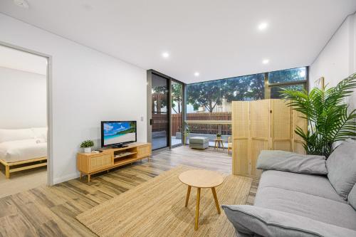 a living room with a couch and a tv at Zetland near Shops & Train with Gym&Pool for 6ppl in Sydney