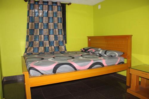 um quarto com uma cama numa sala verde em Pallavi Homestay em Honāvar