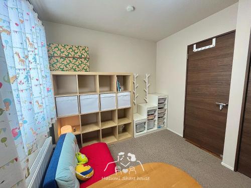 a childs room with a crib and a book shelf at 〈親子二段ベット室【机＆椅子付き 】〉駐車場無料&地下鉄駅から950m　札幌新築戸 in Sapporo