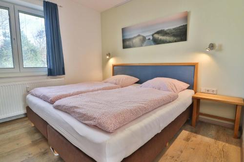 a bedroom with two beds with pink pillows on them at Loog 1 in Langeoog