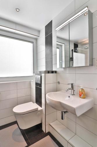 a bathroom with a sink and a toilet and a mirror at Loog 1 in Langeoog