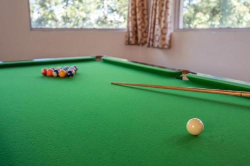 a green pool table with balls and cues on it at Binsar Eco Resort, Binsar - Uttarakhand in Hawālbāgh