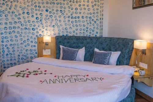 a bedroom with a bed with a happy anniversary sign on it at Binsar Eco Resort, Binsar - Uttarakhand in Hawālbāgh