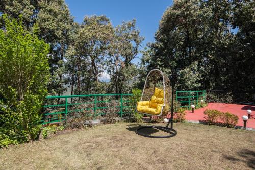 a playground with a yellow swing in a park at Binsar Eco Resort, Binsar - Uttarakhand in Hawālbāgh