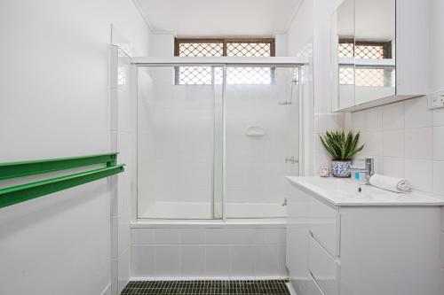 a white bathroom with a shower and a sink at Spacious 1-Bed in the Heart of Teneriffe in Brisbane