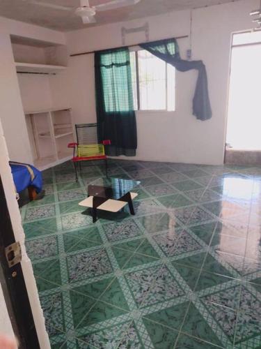 a room with a tile floor with a table and a chair at Cómodo Departamento a 2 cuadras de la playa in Progreso