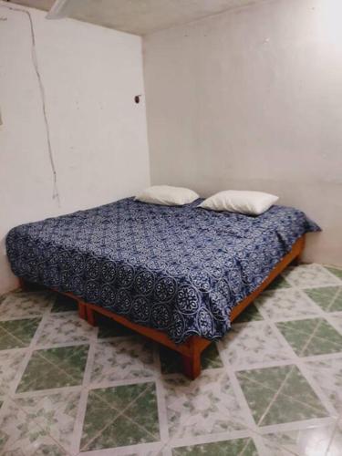 a bedroom with a bed with a blue comforter at Cómodo Departamento a 2 cuadras de la playa in Progreso