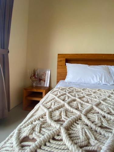 a bedroom with a large white bed with a wooden headboard at Sumbul View Surfcamp in Airsatang