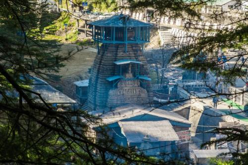 a building with a blue tower in the middle at Binsar Eco Resort, Binsar - Uttarakhand in Hawālbāgh