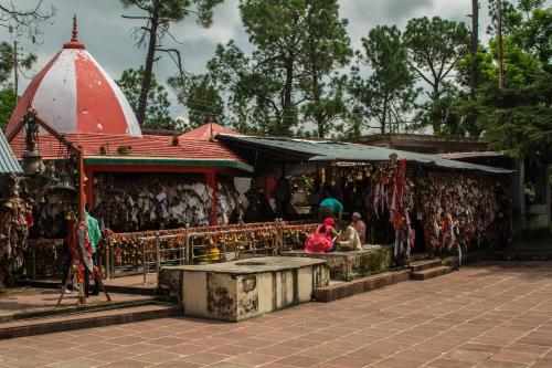 a group of people sitting in front of a temple at Binsar Eco Resort, Binsar - Uttarakhand in Hawālbāgh