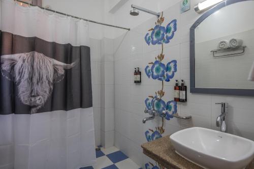 a bathroom with a cow shower curtain and a sink at Binsar Eco Resort, Binsar - Uttarakhand in Hawālbāgh