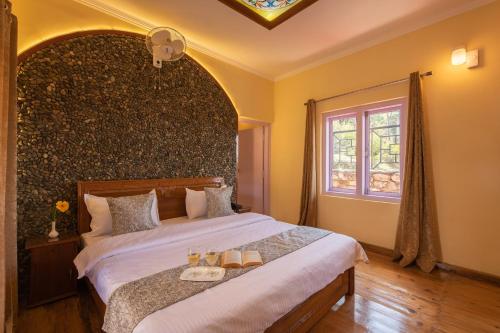 a bedroom with a large bed with a large wall at Binsar Eco Resort, Binsar - Uttarakhand in Hawālbāgh