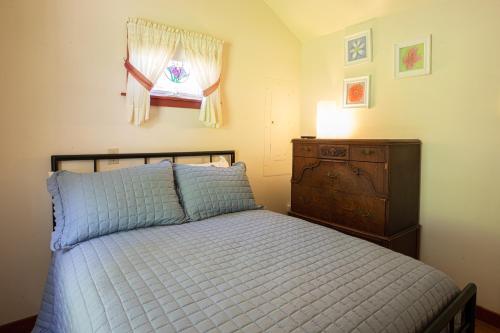 a bedroom with a bed and a dresser and a window at Sunset Cottage #3 in Hamilton