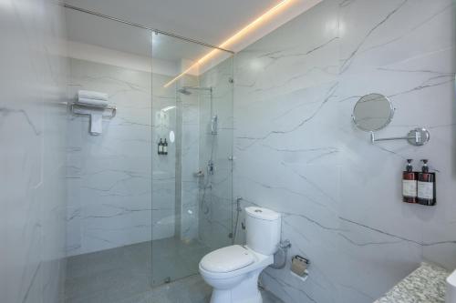 a bathroom with a toilet and a glass shower at Binsar Eco Resort, Binsar - Uttarakhand in Hawālbāgh
