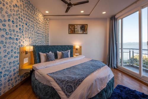 a bedroom with a large bed and a large window at Binsar Eco Resort, Binsar - Uttarakhand in Hawālbāgh
