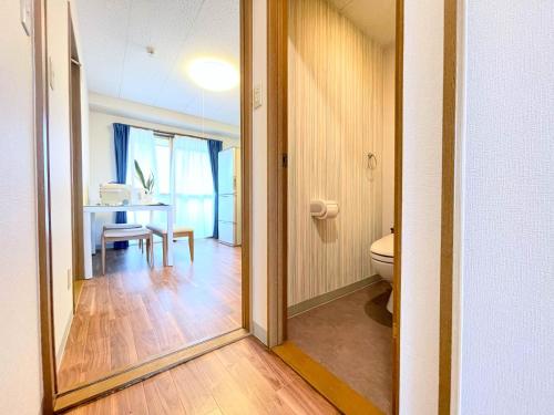 een badkamer met een tafel, een toilet en een spiegel bij エクセルインナガハマ in Nagahama