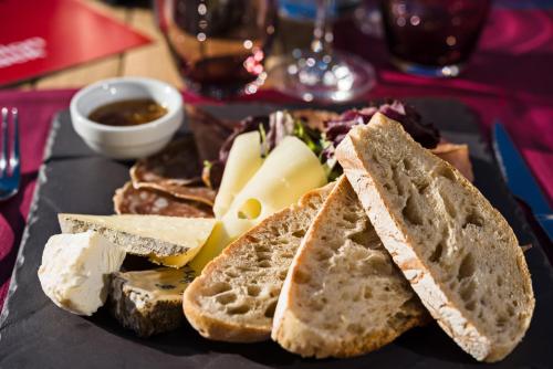 Un plato de comida con pan, queso y salsa. en Marmotel & Spa, en Pra-Loup