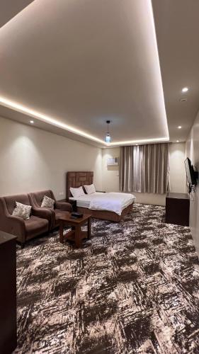 a living room with a bed and a couch at Radiha Hotel Suites in Al Ḩawīyah