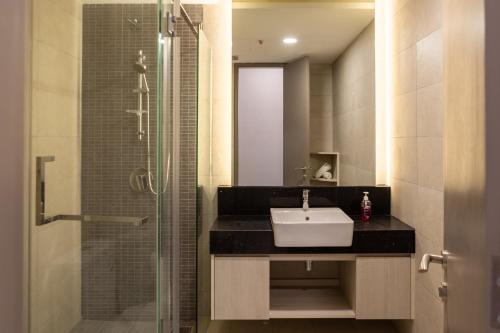 a bathroom with a sink and a glass shower at Societe Hartamas in Kuala Lumpur