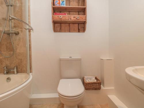 a white bathroom with a toilet and a sink at Pippin in Martin