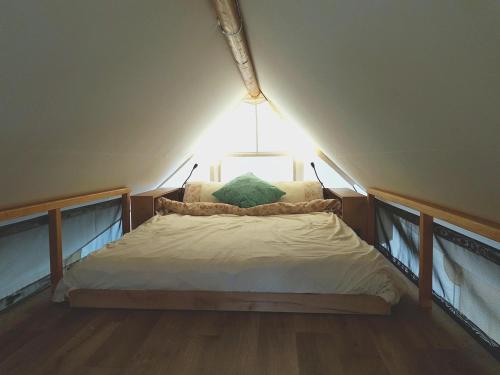 a small bed in a room with a light at Glamp-stan-slapy cz in Neveklov