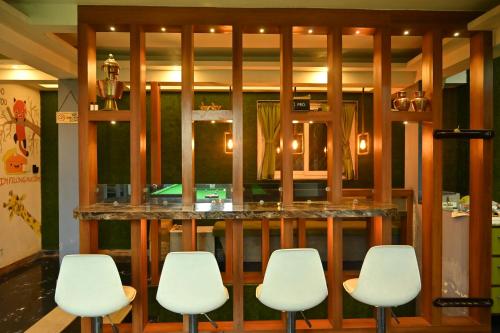 a bar with white chairs in a restaurant at Zingo's Home Stay in Darjeeling