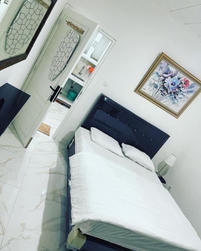 a bedroom with a large bed with a blue headboard at Villa Omar in Cikujang