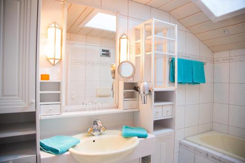 a white bathroom with a sink and a mirror at WOHNEN by LIZZY in Wagrain