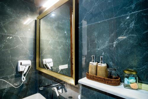 baño con espejo, lavabo y encimera en Chez Lavania - A Boutique Homestay, en Udaipur