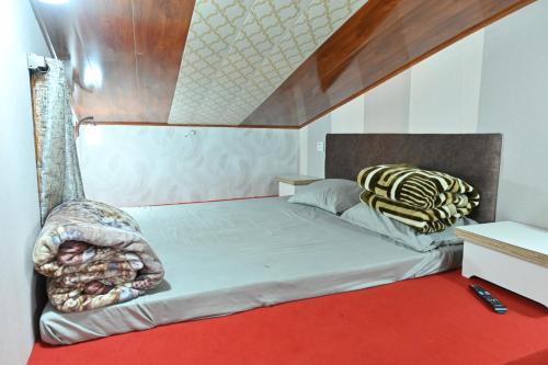 a bedroom with two beds and a red carpet at Zingo's Home Stay in Darjeeling