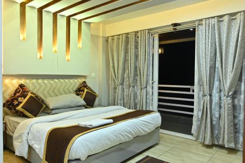 a bedroom with a large bed and a window at Zingo's Home Stay in Darjeeling