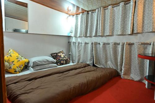 a small bed in a room with curtains at Zingo's Home Stay in Darjeeling
