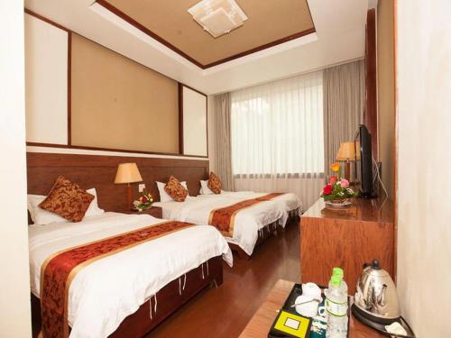 a hotel room with two beds and a television at Sao Mai Hotel - 23 Tôn Đức Thắng - by Bay Luxury in Hanoi