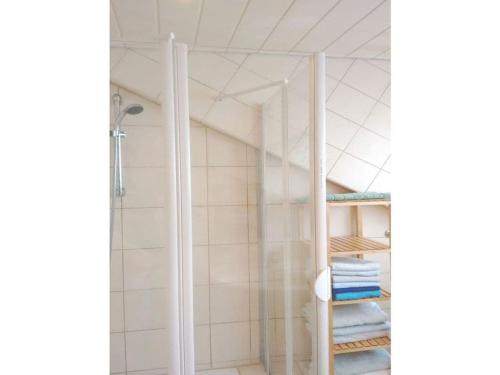 a shower in a bathroom with white tiles at Holiday apartment Wiedmann in Tübingen