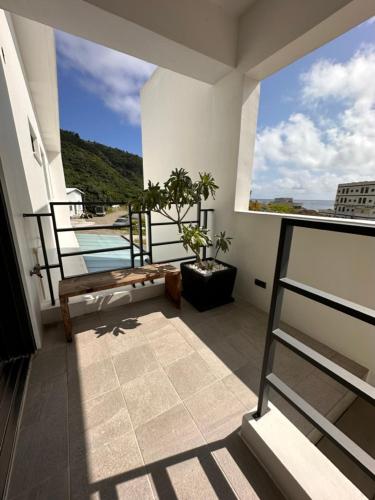 a balcony with a bench and a view of the water at Dawn Valley in Green Island