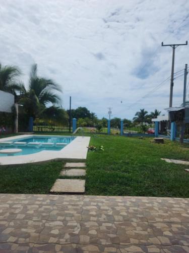 einen Hof mit einem Pool und einem Grasfeld in der Unterkunft Casa Zelaya en Isla San Blas, La libertad salvador in La Libertad