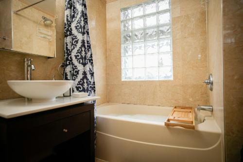 a bathroom with a tub and a sink and a window at Urban Elegance in Philadelphia