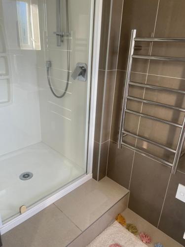 a bathroom with a shower with a glass door at Your home at Cockle Bay in Auckland