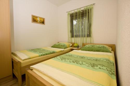 two twin beds in a room with a window at Holiday Home Lana in Korenica