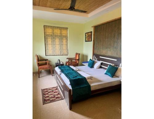 1 dormitorio con 1 cama grande y 1 silla en Kings Cottage, Bhimtal, en Bhimtal