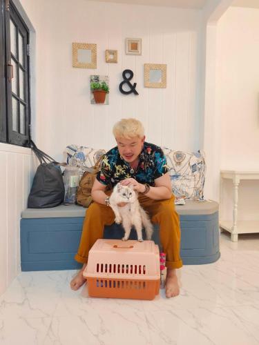 a woman sitting on a couch petting a dog at At Night in Chumphon