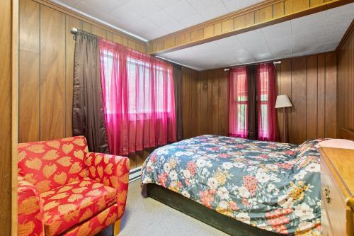 een slaapkamer met een bed en een stoel bij Family Cabin at Rainier Lodge -0.4 m from entrance in Ashford