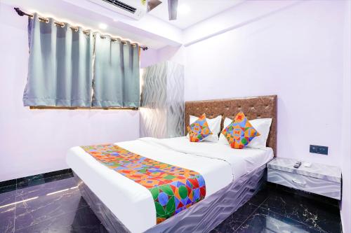 1 dormitorio con 1 cama grande y almohadas coloridas en FabExpress Kirtiraj, en Panvel