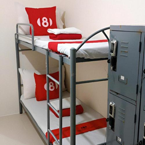 - un lit superposé avec des oreillers rouges et un casier dans l'établissement 8 Condotel, à Manille
