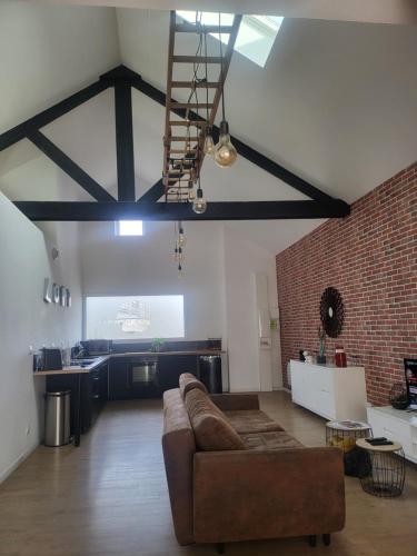 un salon avec un canapé et un mur de briques dans l'établissement Atelier Détente, à Liévin