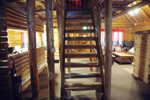 uma escada de madeira num quarto com uma sala de estar em Log Cabin at Rainier Lodge (0.4 miles from entrance) em Ashford