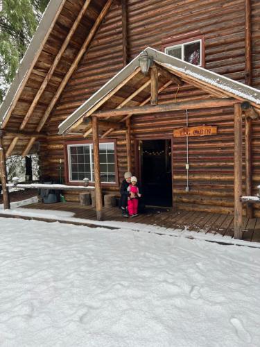 two children standing in the doorway of a log cabin at Log Cabin at Rainier Lodge (0.4 miles from entrance) in Ashford