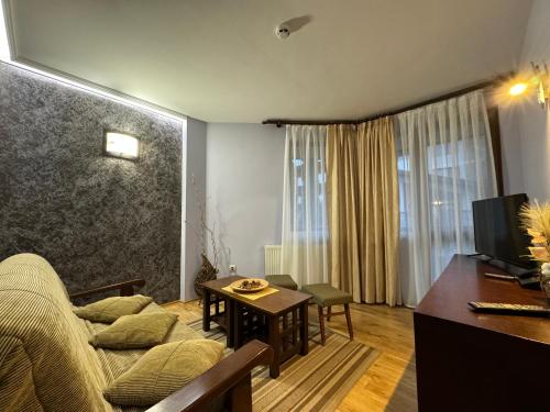 a living room with a couch and a table at Family Hotel Eterno in Tsigov Chark