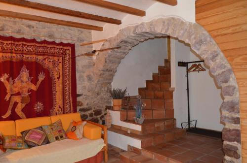 an archway in a room with a couch and a staircase at La Casa Del Teix in Eslida