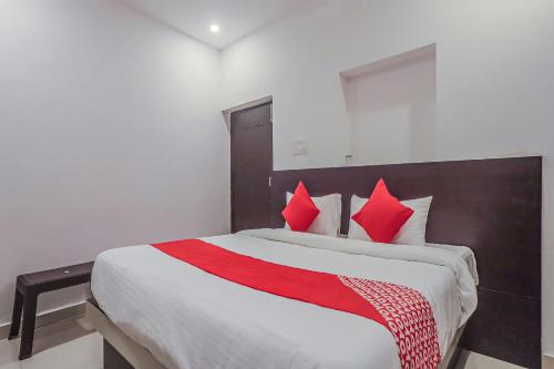 a bedroom with a large bed with red pillows at OYO Flagship Hotel Sai Palace in Patna